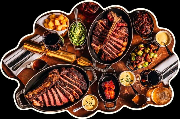 Sliced steaks and sides laid out across a table